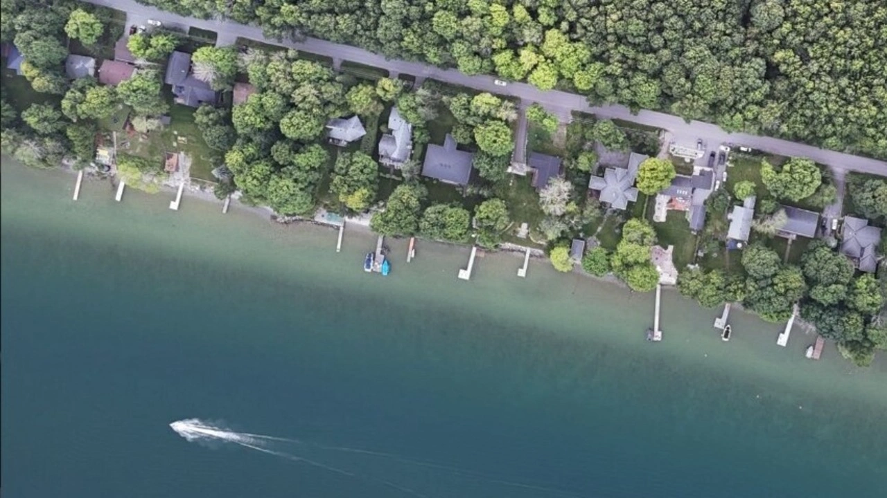 Aerial view of lakeside houses with a speeding boat