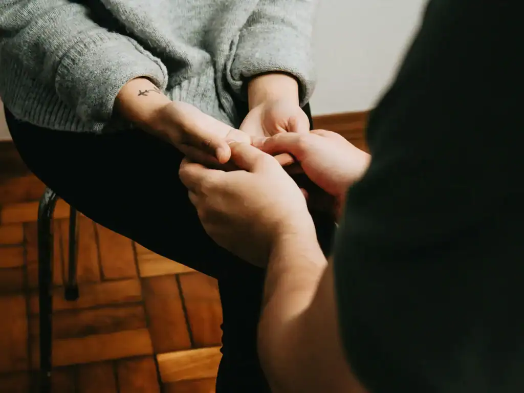 Hopeful hands holding each other, symbolizing support and caring in family and mental health services.