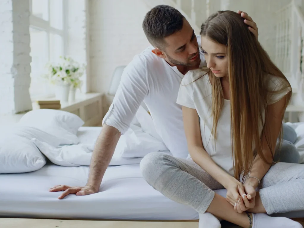 Couple sitting close on a bed, rebuilding respect and closeness