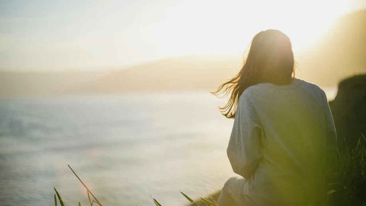 Woman facing the sea, reflecting on complex PTSD symptoms