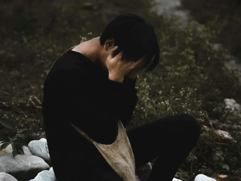 Man sitting on the ground, living with complex post-traumatic stress disorder