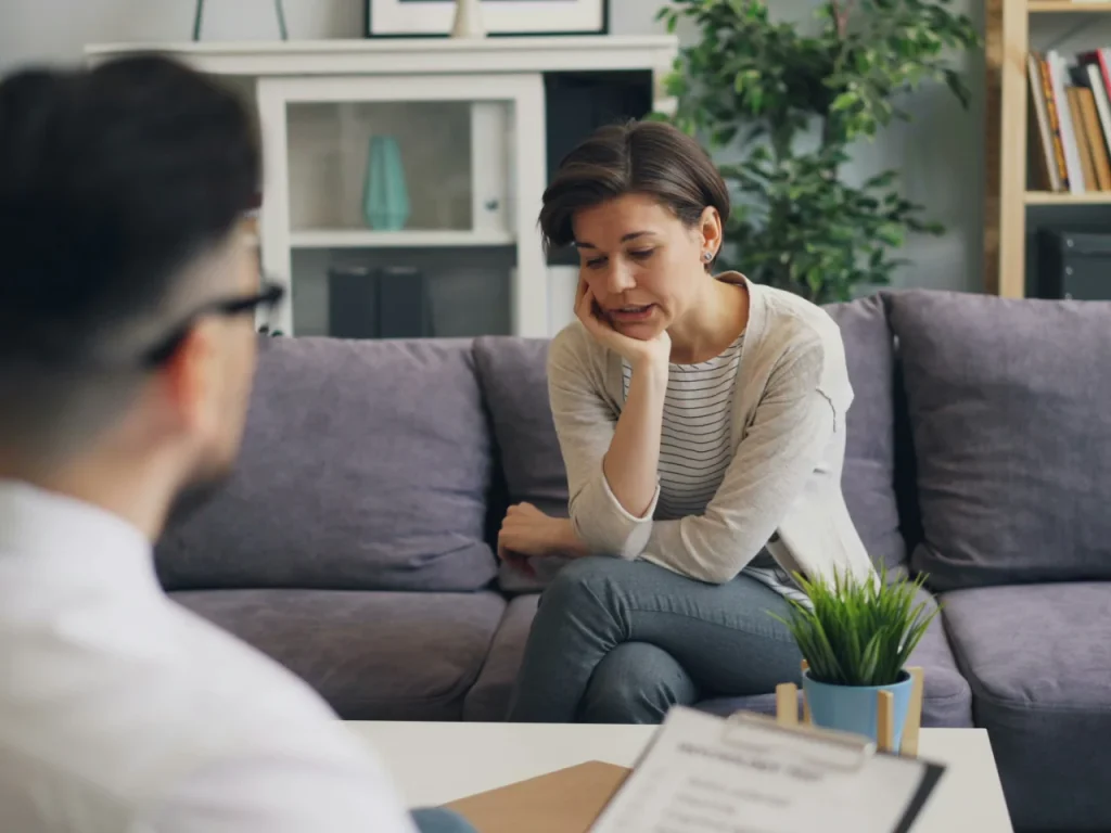 Woman talking with a man on a couch during a couples therapy session