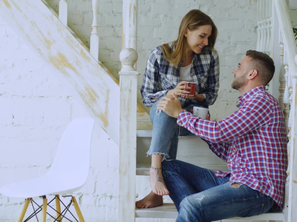 Couple talking on a staircase, comparing Gottman Method and emotionally focused therapy